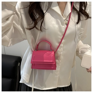 Close-up of bright pink mini crossbody bag with top handle and magnetic flap design