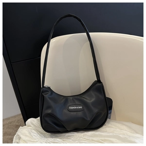 Detail of the pleated black PU leather shoulder bag featuring a fashion logo patch