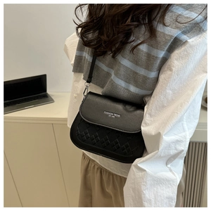 Détail du sac bandoulière noir avec motif matelassé et lettrage FASHION TREND sur modèle