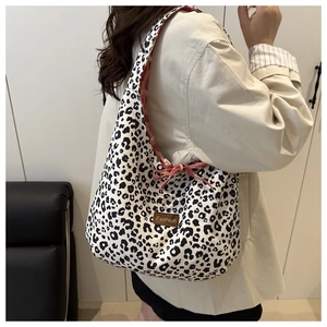 Detail of leopard print tote bag with brown leather tag and floral fabric lining