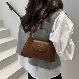 Sac sous le bras en cuir marron foncé avec boucle papillon argentée et bandoulière tressée