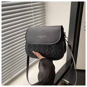 Détail du sac bandoulière noir en similicuir matelassé avec inscription tendance mode