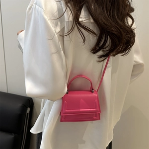 Minimalist pink mini crossbody bag with top handle shown on model for a summer fashion look