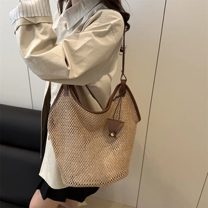 Summer woven straw tote bag with brown leather straps shown on model for daily commute