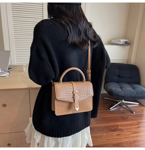 Détail du sac à main marron à texture tressée avec boucle métallique en cœur