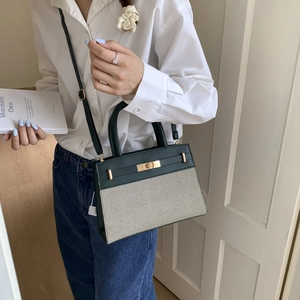 Minimalist beige canvas and dark green leather crossbody bag with golden metal twist lock