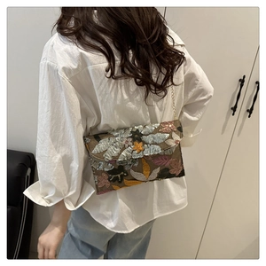 Macro view of detailed floral sequins and embroidery on the elegant evening clutch bag