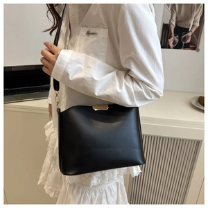 Détail du sac bandoulière noir en demi-lune avec des finitions métalliques dorées chic