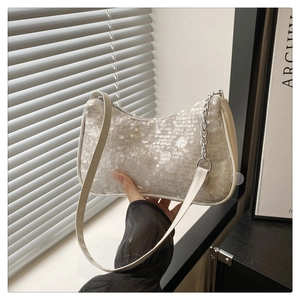 Detailed close-up of sequined hobo bag with silver chain and leather shoulder strap