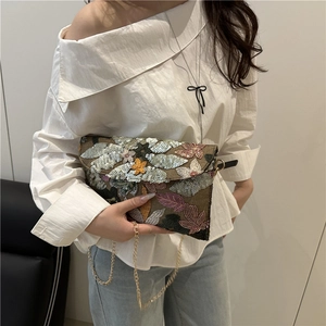 Ethnic envelope clutch with sequins and floral embroidery on a chic woven crossbody bag
