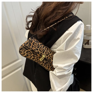 Close-up of leopard print baguette bag featuring a gold metal twist lock buckle