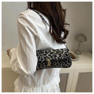 Detail of vintage leopard print underarm bag with gold lock buckle on model shoulder