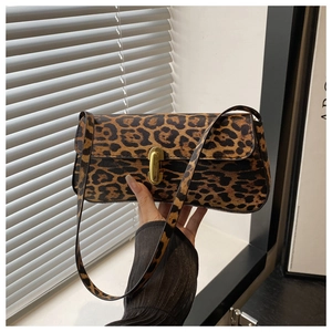 Detail of leopard print shoulder bag featuring a sleek gold metallic capsule lock closure