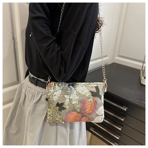 Detail of floral embroidery and shiny sequins on a square chain clutch evening bag