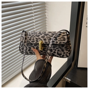 Close-up of leopard print underarm bag with elegant gold metal buckle and sturdy strap