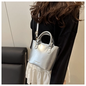 Detail of silver metallic handbag with FASHION & BAGS logo and golden strap buckle