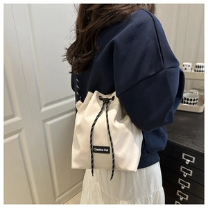 Vue détaillée du sac seau en toile beige avec cordon de serrage et logo Creative Cat