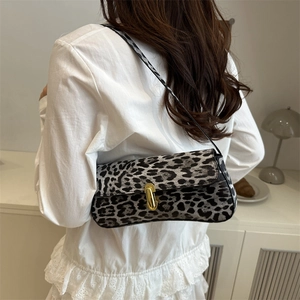 Leopard print baguette bag with gold metal buckle shown in a lifestyle setting