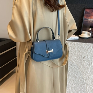 French vintage dark blue leather handbag with golden H buckle shown on a model