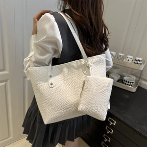 White woven tote bag set with small matching pouch for women in a minimalist home setting