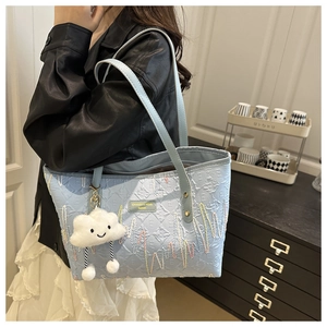 Borsa tote celeste trapuntata con ricami colorati e ciondolo a forma di nuvola bianca