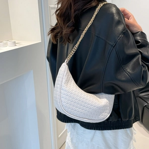 Borsa hobo a mezzaluna intrecciata bianca con catena dorata indossata dalla modella