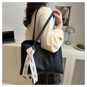 Detail of black tote bag with white contrast stitching and fashion print silk scarf