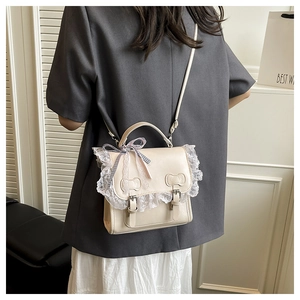 Détail du mini sac beige avec matelassage oreilles de chat et ruban à carreaux