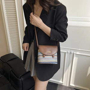Women's woven straw crossbody bag with colorful stripes and brown leather flap cover
