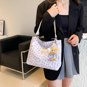 Sommerliche lila Hobo-Tasche mit Schleifen-Details und Plüschanhänger für Damen
