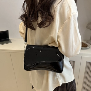 Glossy black patent leather mini square bag with adjustable shoulder strap and gold buckle