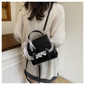 Détail d'un sac à dos Lolita noir avec bordure dentelle et nœud à carreaux rose