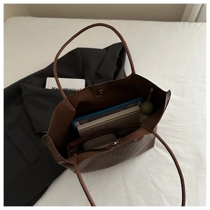 Internal view of brown woven tote bag showing large capacity for tablet and umbrella