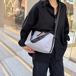 Minimalist lavender nylon messenger bag with wide black strap and orange zipper detail