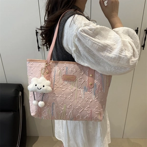 Borsa tote rosa con goffratura di lettere e simpatico ciondolo a nuvola bianca vista laterale