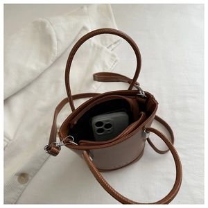 Top view of a brown faux leather bucket bag with silver hardware and a top handle