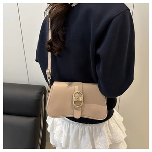 Dettaglio borsa a tracolla beige minimalista con fibbia dorata e trama in pelle fine