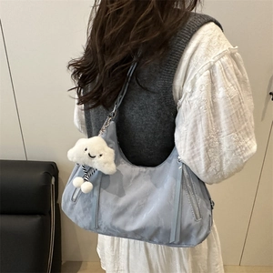 Chic light blue nylon hobo bag for women with cloud plush charm in a casual outfit