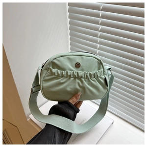 Dettaglio della borsa a tracolla in nylon verde menta con logo M e tasca pieghettata