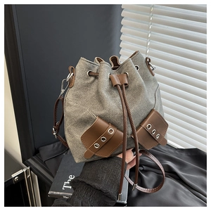 Detailed macro of vintage grey canvas bucket bag with brown faux leather trim and drawstring