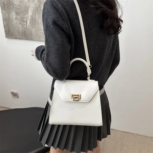 Minimalist white Kelly-style handbag with gold hardware shown on a model