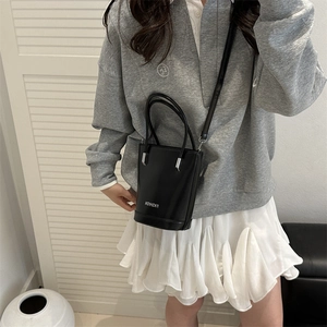 Minimalist black bucket bag with silver handles and adjustable strap for women