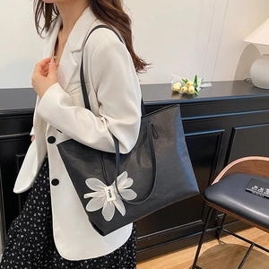Große schwarze Shopper-Tasche mit Lychee-Struktur und Blumenanhänger für den Alltag