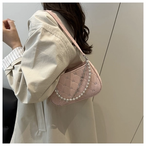 Detail of pink quilted baguette bag with white pearl and silver chain shoulder straps