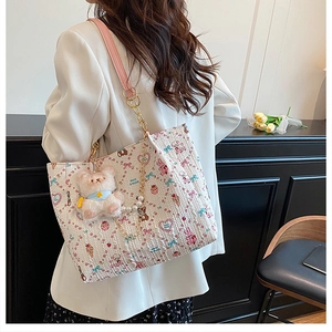 Close-up of canvas tote bag featuring cute cartoon animal prints and chain shoulder strap