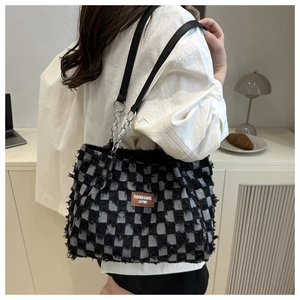 Chic black and white checkered tote bag with fringe edge and silver chain details