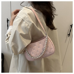 Detail of light pink quilted shoulder bag with elegant pearl and metal chain strap