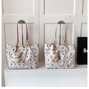 Close-up of quilted tote bags with heart and animal prints and plush bear charms