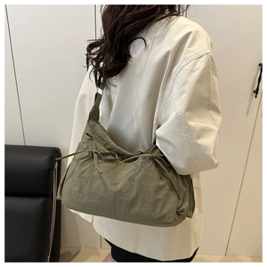 Green lightweight nylon shoulder bag detail featuring drawstring bow and pleated design