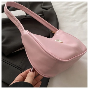 Detail shot of the pink PU leather shoulder bag featuring a silver heart emblem and zipper